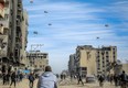 Palestinians run along a street as humanitarian aid is airdropped in Gaza City on March 1, 2024.