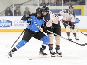 Montreal's Marie-Philip Poulin (right) battles for the puck with Toronto's Renata Fast during the first period of PWHL hockey action in Toronto, on Friday, March 8, 2024.