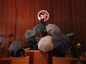 FILE - Protesters deface the Hong Kong logo at the Legislative Council to protest against the extradition bill in Hong Kong on July 1, 2019. A Hong Kong court sentenced 12 people Saturday, March 16, 2024 to prison over the storming of the city's legislative council building at the height of the anti-government protests in 2019.