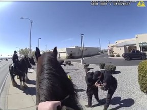 This photo taken from Albuquerque Police Department police video shows police making an arrest on March 20, 2024 after a chase with a horse-mounted police officer in Albuquerque, N.M. The shoplifter was detained outside a Walgreens.