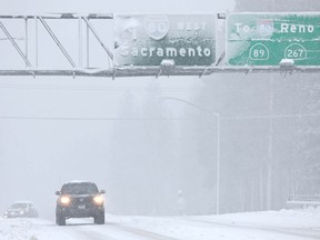 Vehicles drive as snow falls north of Lake Tahoe