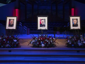 FILE - Portraits of Burnsville police officers Paul Elmstrand, 27, firefighter-paramedic Adam Finseth, 40, and officer Matthew Ruge, 27, left to right, are on display before a live stream of the memorial service for the three men at Prince of Peace in Burnsville, Minn., on Wednesday, Feb. 28, 2024. Minnesota's U.S. Attorney will provided an update, Thursday, March 14, on last month's fatal shooting of two police officers and a firefighter-paramedic who went to their aid.