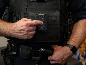 A police officer demonstrates recording on a body camera.