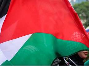 A protester carries a Palestinian flag on March 2, 2024 in Kuala Lumpur, Malaysia. (Getty Images)