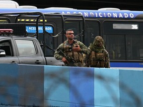 Police snipers stand guard outside the Novo Rio bus terminal