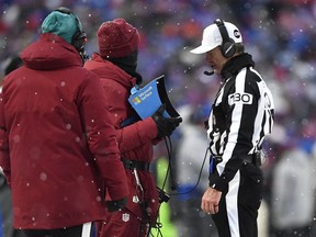 FILE - Referee Land Clark reviews a play during the second half of an NFL football game between the Buffalo Bills and the Atlanta Falcons in Orchard Park, N.Y., Jan. 2, 2022. The Indianapolis Colts are proposing a rule change that would allow for challenges of penalty calls in the last two minutes of the half. The NFL released a list of several rule change proposals Wednesday, March 13, made by teams.