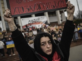 A woman holds a sign during a protest in Kyiv, Ukraine, Sunday March 24, 2024, to demand the freedom of Ukrainian Mariupol's Azovstal defenders still being held prisoners by Russia.