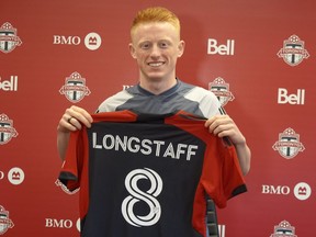 Newly-signed Toronto FC midfielder Matty Longstaff holds up his jersey after training in Toronto on Friday, March 1, 2024.