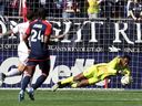 Toronto FC goalkeeper Sean Johnson, right, makes a save in the first half of an MLS soccer match against the New England Revolution, Sunday, March 3, 2024, in Foxborough, Mass. Toronto FC will be without Johnson and fullback Richie Laryea for two to three weeks due to hamstring strains.