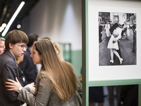 People speak next to a famous photograph of a sailor kissing a nurse