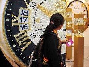A visitor walks past a watch advertisement