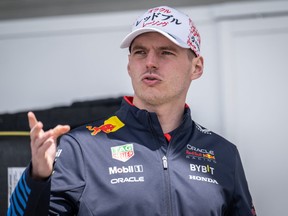 Red Bull Racing driver Max Verstappen gestures in the paddock.