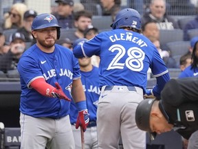 Toronto Blue Jays' Alejandro Kirk, left, greets Ernie Clement (28) after Clement hit a home run against the New York Yankees.
