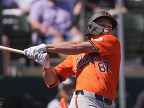 Baltimore Orioles Jackson Holliday (87) swings at a pitch in the first inning of a spring training game.