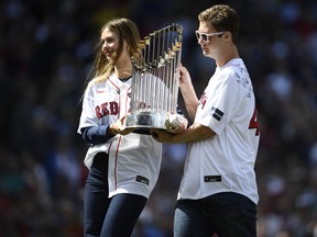 Brianna Grace Wakefield, left, and Trevor Wakefield hold the 2004 World Series trophy.