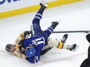 Boston Bruins defenceman Charlie McAvoy exchanges blows with Toronto Maple Leafs' Max Domi earlier this season.