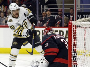 Boston Bruins' David Pastrnak slips the puck past Carolina Hurricanes goaltender Frederik Andersen.