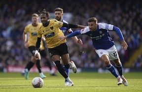 Maidstone United's Lamar Reynolds, left, and Ipswich Town's Dominic Ball battle for the ball during the English FA Cup fourth round.