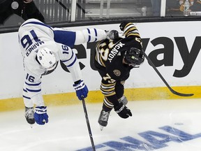 Toronto Maple Leafs' Mitch Marner and Boston Bruins' Charlie McAvoy compete for the puck.