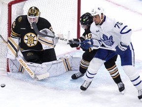 Boston Bruins goaltender Linus Ullmark makes a save while Toronto Maple Leafs' Ryan Reaves tries to tip the puck.