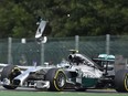 A piece of wing flies over Mercedes-AMG's Nico Rosberg after a collision with teammate Lewis Hamilton in 2014.