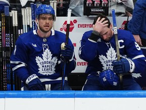 Toronto Maple Leafs' Max Domi, left, and John Tavares react on the bench during Game 4.