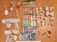 A witness spotted three large black cases buried near a local Prince George trail on April 1, 2024, and police recovered a large cache of drugs and cash inside.