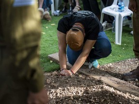 Avraham Harush, father of Israeli solider Sergeant Reef Harush, mourns over his grave in Ramat David, Israel, Sunday, April 7, 2024.