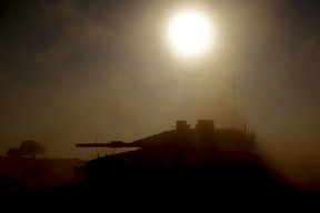 Israel's southern border with the Gaza Strip shows an Israeli tank silhouetted against the sun as it rolls near the Palestinian territory on April 17, 2024, amid the ongoing conflict between Israel and the militant group Hamas.