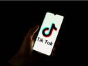 This photograph taken on April 19, 2024 shows a smartphone displaying the logo of Chinese social media platform Tiktok in an office in Paris.