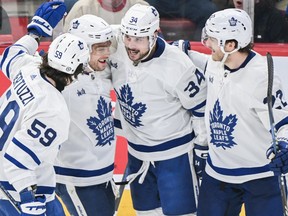 Maple Leafs' Auston Matthews (34) celebrates with teammates after scoring against the Canadiens during second period NHL action in Montreal, Saturday, April 6, 2024.