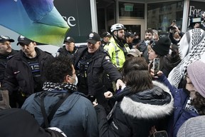 Police clash with protesters outside a fundraising event for Prime Minister Justin Trudeau, in Toronto, Friday, March 15, 2024.