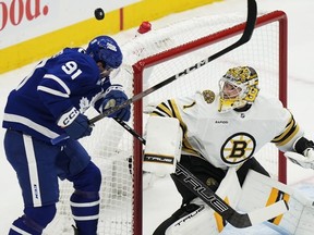Maple Leafs' John Tavares is hit by the puck as Boston Bruins goaltender Jeremy Swayman looks on during the first period in Game 3 of their first-round playoff series in Toronto on Wednesday, April 24, 2024.