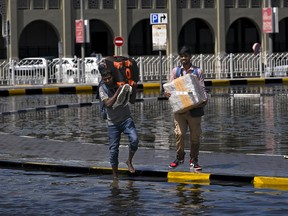Men prepare to cross a flooded street