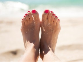 Woman's pretty feet in the sand.