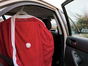Santa Claus costume in the doorway of an open car