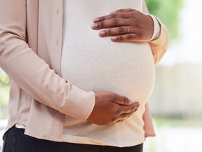 Woman holding pregnant belly.