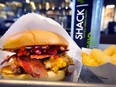 Bacon cheeseburger sandwich and fries are served at a Shake Shack restaurant