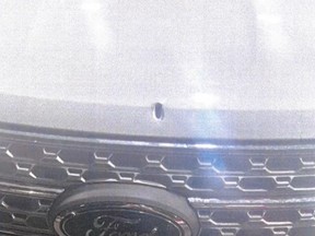 The Holly Springs Police Department released images of an officer's patrol car with a bullet hole in the front hood.