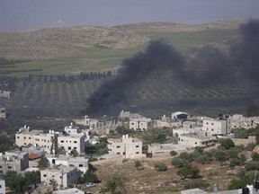 Smoke fills the sky after Israeli settlers set fire to the properties of Palestinian villagers in the West Bank village of al-Mughayyir, Saturday, April 13, 2024.