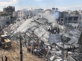 Palestinians look for survivors following Israeli airstrike in Nusseirat refugee camp, Gaza Strip, Tuesday, Oct. 31, 2023.