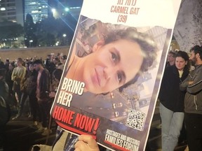 A person holds up a sign with the picture of Carmel Gat, an Israeli taken hostage by Hamas fighters on Oct. 7, 2023.