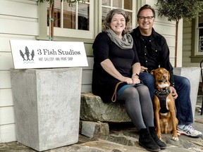 Husband and wife artist team Annie Galvin, left, and Eric Rewitzer pose with their dog Woody in front of their new 3 Fish Studios art gallery in Amador City, Calif., in 2023.