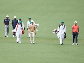 Left to right: Canadians Corey Conners, Adam Hadwin, Mike Weir, and Nick Taylor walk down the second fairway with their caddies during a practice round prior to the 2024 Masters Tournament in Augusta, Ga, yesterday.  Getty Images