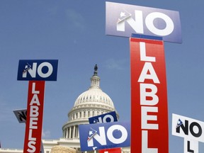 People with the group No Labels hold signs during a rally on Capitol Hill in Washington, July 13, 2013.