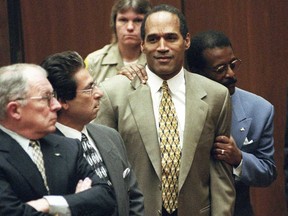 In this Oct. 3, 1995 file photo, attorney Johnnie Cochran Jr. holds O.J. Simpson as the not guilty verdict is read in a Los Angeles courtroom during his trial in Los Angeles.