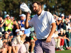 Scottie Scheffler tips his hat to the crowd on the 18th green after finishing his round during the third round of the 2024 Masters Tournament at Augusta National Golf Club in Augusta, Ga., Saturday, April 13, 2024.