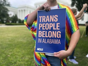 A person holds up a sign reading, "Trans People Belong in Alabama," during a rally outside the Alabama Statehouse in Montgomery, Ala., on International Transgender Day of Visibility, March 31, 2023.