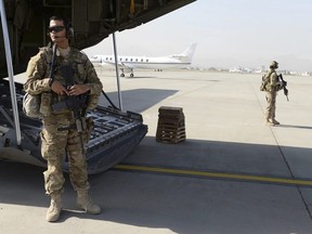 Wilmer Puello-Mota, left, a member of the U.S. Air Force, provides security at Hamid Karzai International Airport in Kabul, Afghanistan, on Aug. 28, 2015. Puello-Mota, a U.S. Air Force veteran and former elected official in Massachusetts who fled the U.S. after being charged with possessing sexually explicit images of a child, told his lawyer he joined Russia’s army.