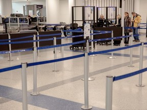 Passengers pass through the security checkpoint at the Newark Liberty International Airport on March 27. When the airport is not crowded, the gates near unused security sections are intentionally closed to block people from passing by without being checked. MUST CREDIT: Yehyun Kim for The Washington Post